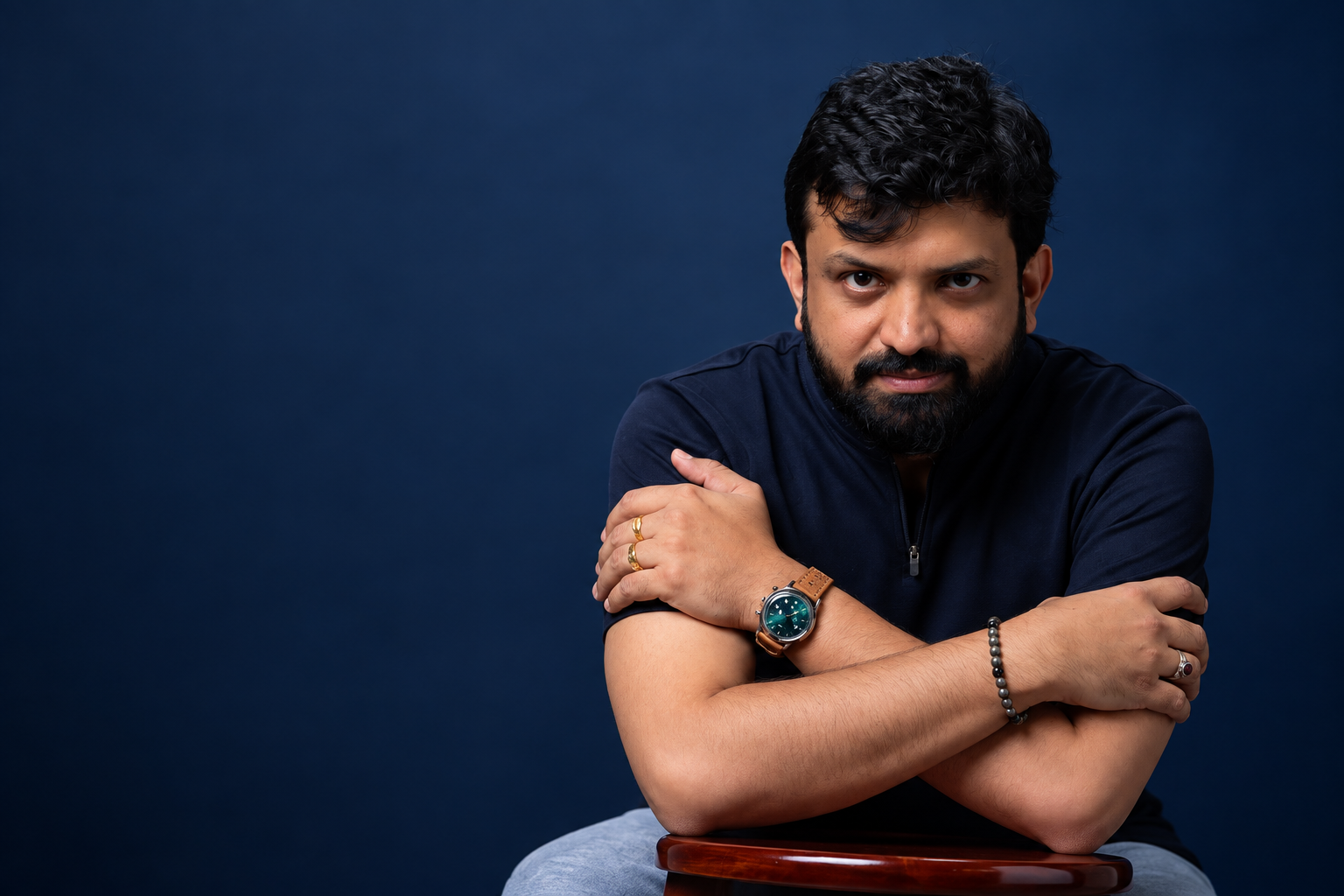 Gijo Uthuppu, writer and director, seated with his arms crossed